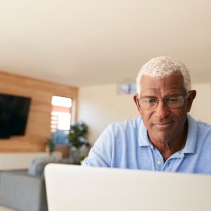 Senior African American Man Using Laptop To Check Finances At Home