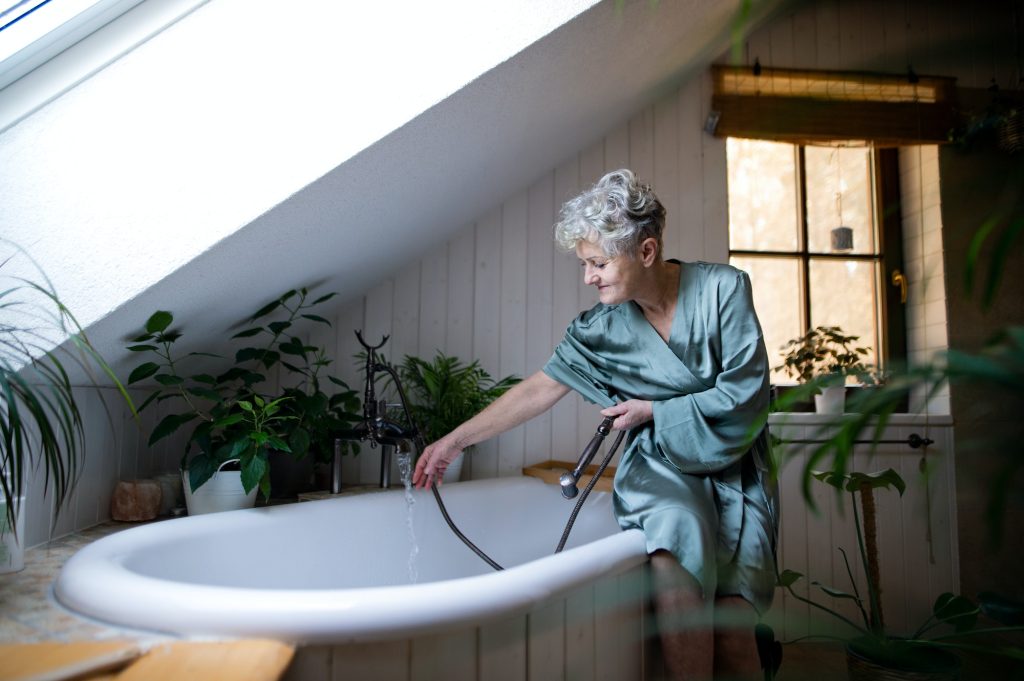 Top view of senior woman in bathroom preparing for a bath at home